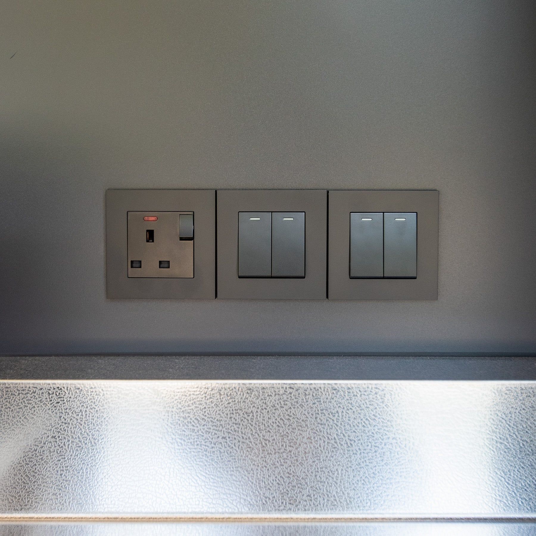 A double socket and two switch plates on the wall above the cube's worktop (supplier photograph)