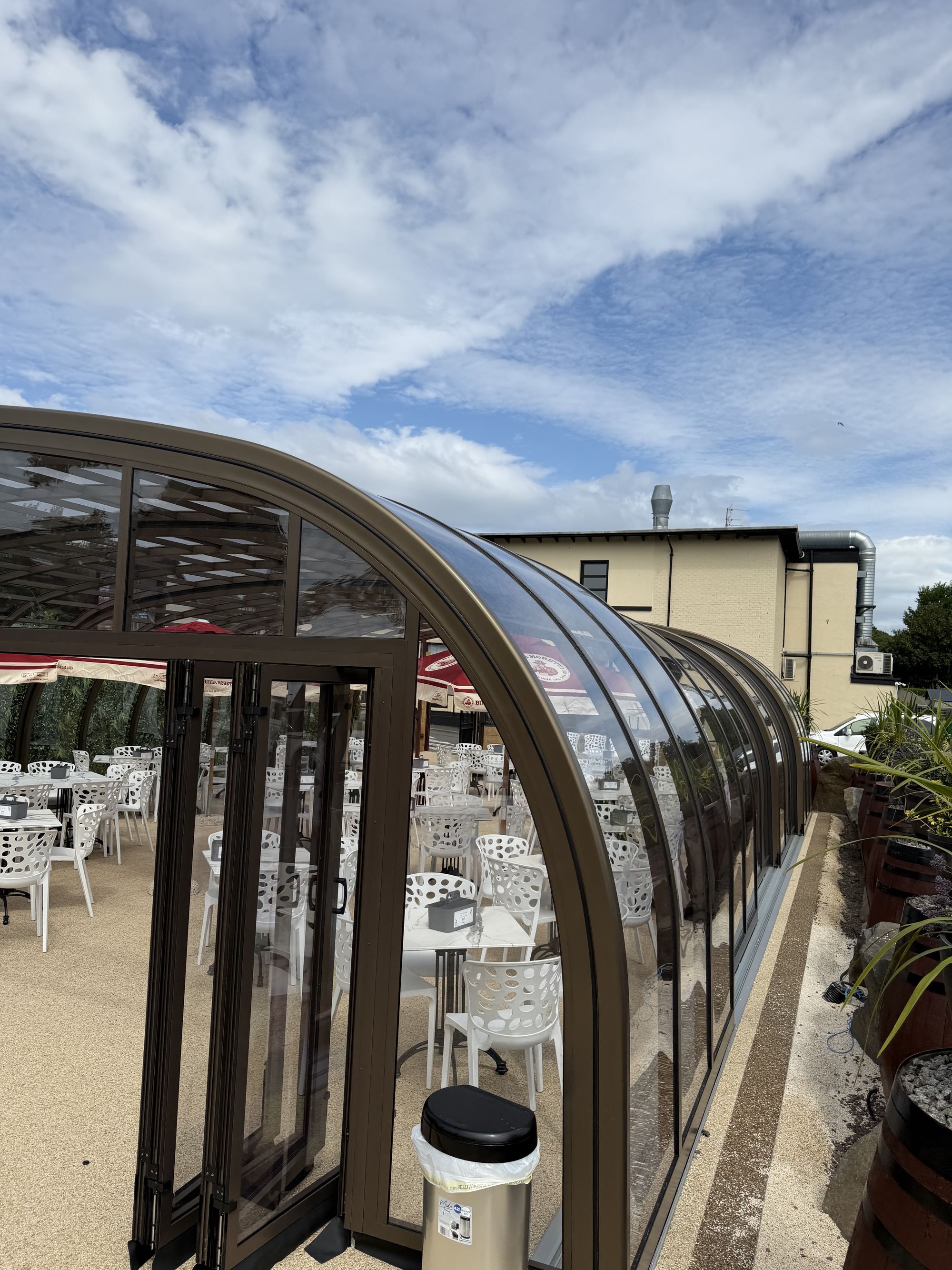The glasshouse seen from the side, with the pub building behind