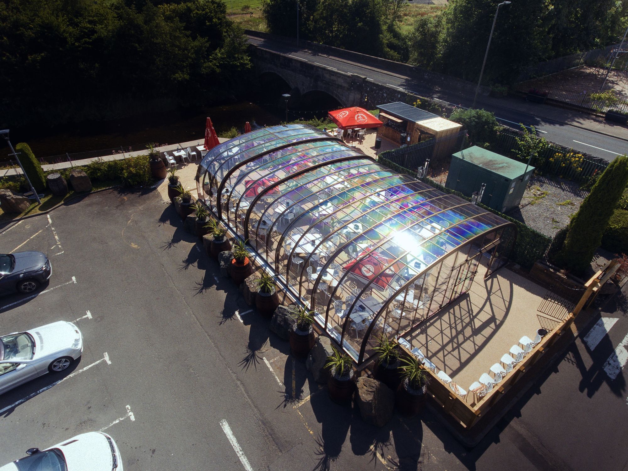 The glasshouse from the air, its roof in overlapping sections above the car park side
